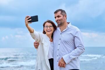 Happy mature couple taking selfie photo on smartphone.