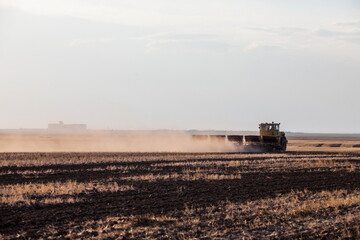 Kostanay Province, Kazakhstan - May 01, 2019: Tractor seeds wheat in field. Spring sowing season.