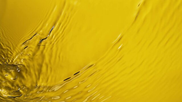 Super slow motion of water surface on light yellow background. Filmed on high speed cinema camera, 1000 fps.