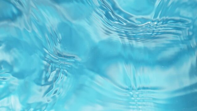 Super slow motion of water surface on light blue background. Filmed on high speed cinema camera, 1000 fps.