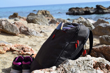 glasses and passport in a backpack on the beach