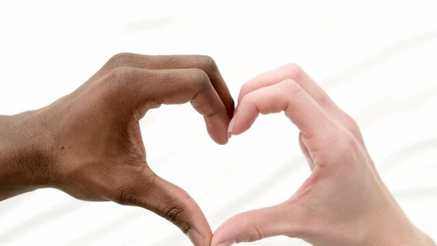 Heart from hands close up multiracial couple african man and caucasian woman lovers, Concept mixed family love on white.