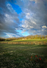 Fototapeta premium Approaching storm over Veteran’s park dog park in front of cell phone repeater tower on a small hill.