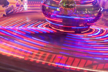 a fair with rotating rides in neon colors