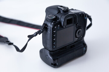DSLR camera body in black color on white background. DSLR camera with battery grip attached.