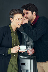 Coffee and gossip go together so well. Cropped shot of two colleagues gossiping by the water cooler during a coffee break.