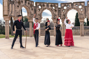 in a square in front of some ornamental arches, a flamenco master instructs his apprentices - obrazy, fototapety, plakaty