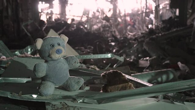 2022 Russian invasion of Ukraine war child teddy bear toy building ruins city destruction building damage war torn. Terror attack bomb shell civilian bombed building destroy city war concept explosion
