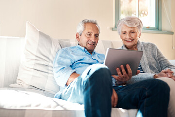 Embracing the era of smart technology. Shot of a senior couple using a digital tablet together in their living room at home.