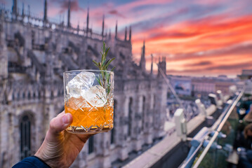 Naklejka premium Drinking delicious cocktail with an amazing view of the Milan Cathedral in Italy.