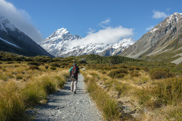 Man hiking Hooker Valley track, Mt Cook in the distance. South Island.