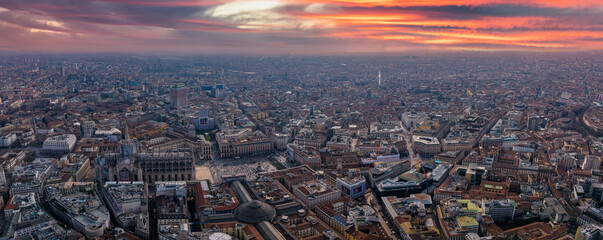 Naklejka premium Aerial view of Piazza Duomo in front of the gothic cathedral in the center. Drone view of the gallery and rooftops during the day. Milan. Italy,