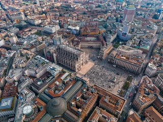  Aerial view of Piazza Duomo in front of the gothic cathedral in the center. Drone view of the gallery and rooftops during the day. Milan. Italy, © ingusk