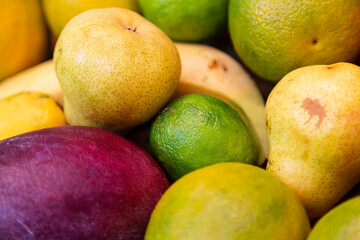 Close up of juicy fruits. Pear, lime, mago, banana, orange. Good diet, healthy lifestyle.