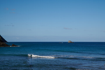 Fototapeta premium The chopping waves of the sea and the little tiny boat riding the waves.