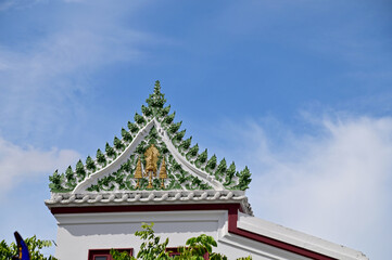 Part of the Roof of a temple in Thailand. Traditional Thai style pattern on the roof of a temple with Blue Sky Background.