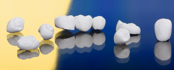 High aesthetic zirconia dentures and crowns on colorful background. Set of single dentures and...