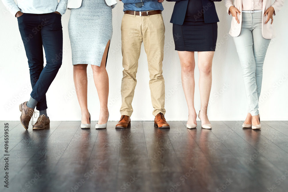 Poster Side by side. Low angle shot of a group of unrecognizable work colleagues standing with their arms folded against a white background.