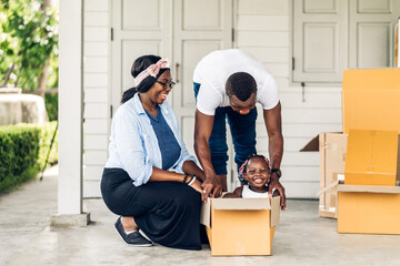 Portrait of enjoy happy love black family african american father and mother with little african girl smiling sitting in cardboard box at new home unpacking during move and having fun