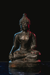 statue of buddha and black background light.