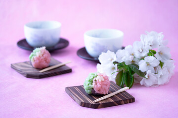 Fototapeta na wymiar 春の和菓子　さくらと若葉の練り切りと緑茶と桜の小枝（オオシマザクラ）