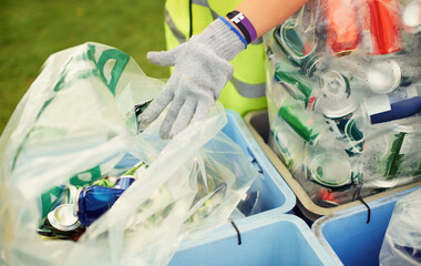 The cleanup after the party. A cleaner picking up beer cans and other trash after a music festival.
