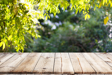 Empty wooden table with garden bokeh for a catering or food background with a country outdoor...