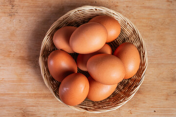 basket of fresh chicken eggs on a wooden table from agriculture farm.