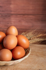 basket of fresh chicken eggs on a wooden table from agriculture farm.