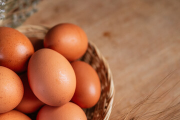 basket of fresh chicken eggs on a wooden table from agriculture farm.