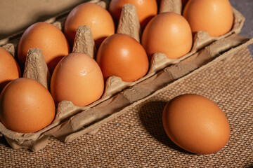 chicken eggs in an open egg carton. Fresh chicken eggs background.
Top view with copy space. Natural healthy food and organic farming concept. Eggs in box