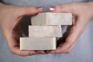 Woman holds a stack of handmade soap.