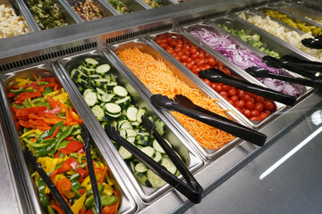 variety of colorful fresh vegetable salad in container in restaurant