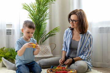 Montessori material. Home education. Mom and son are learning musical instruments.