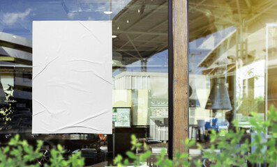Mockup white paper or white sticker poster displayed on the front of the restaurant, coffee shop,...