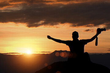 Silhouette of a man on a mountain top. Person silhouette on the rock. The concept of fighting until success is victorious.