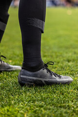 Close up view of a soccer (football) player's legs and cleats. Vertical Generic soccer or football...