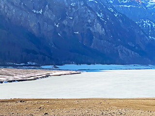 Frozen Klöntalersee or Klontaler Lake during early spring in the Alpine valley Klöntal (Kloental or Klontal) and in the Glarus Alps mountain massif - Canton of Glarus, Switzerland (Schweiz)