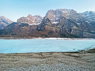 Frozen Klöntalersee or Klontaler Lake during early spring in the Alpine valley Klöntal (Kloental or Klontal) and in the Glarus Alps mountain massif - Canton of Glarus, Switzerland (Schweiz)