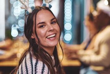 Im a reindeer tonight. Portrait of a cheerful young woman wearing a festive hat at home during...