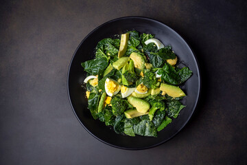 Avocado salad with broccoli, boiled egg in white vintage bowl on light salad
