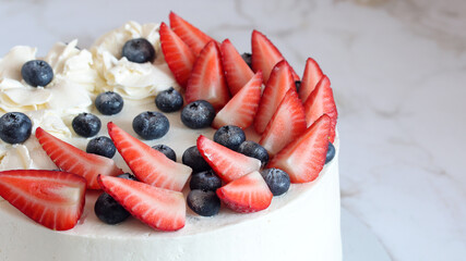 blueberries and strawberry slices on the cake.