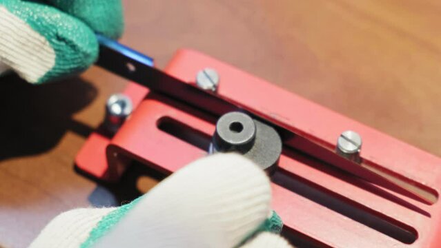 The master prepares the machine and tools for sharpening knives and scissors