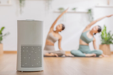 Air purifier in cozy white Living room for filter and cleaning removing dust at home with woman...