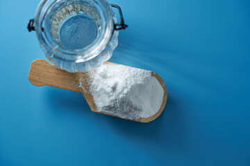 white vinegar and baking soda against blue background