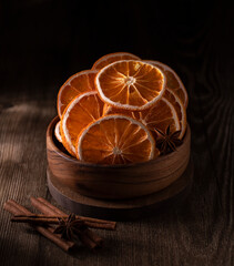 Orange chips in a wooden bowl on the table close-up.