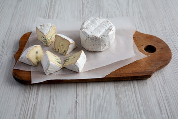 Alpine Blue Cheese on a rustic wooden board, side view.