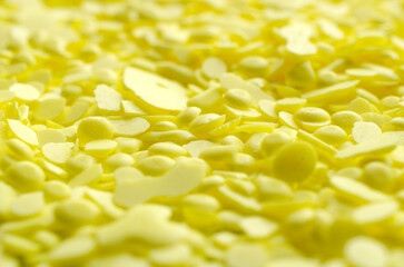 Pile of yellow sulfur granules used in medicine, fertilizers. Yellow sulfur background, texture, top view. Heap of sulfur powder, background, texture, top view.