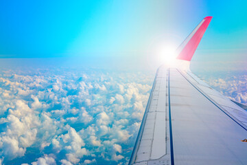 wings of airplanes during the flight look from the passenger window. There are white clouds in the...