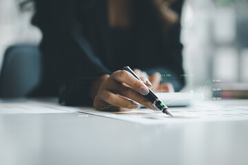 A business woman examines data on financial documents, company financial reports, graphics showing financial and numerical growth data. The concept of financial management to grow and be profitable.
